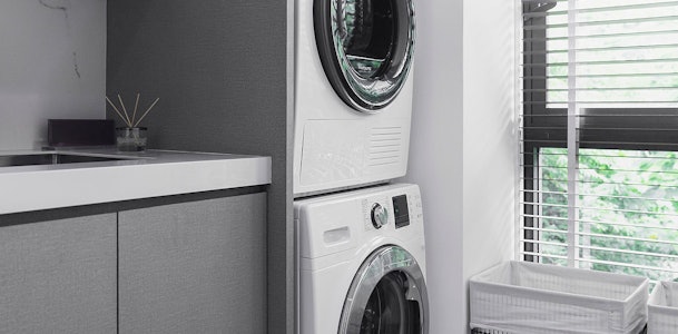 Droger gestapeld op wasmachine in moderne wasruimte