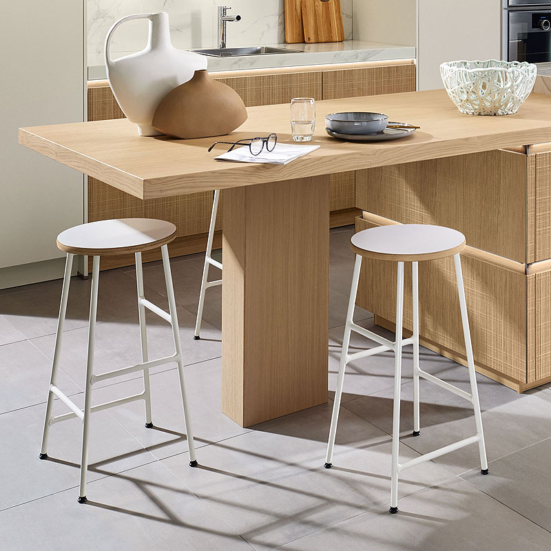 Houten eettafel met moderne barkrukken.