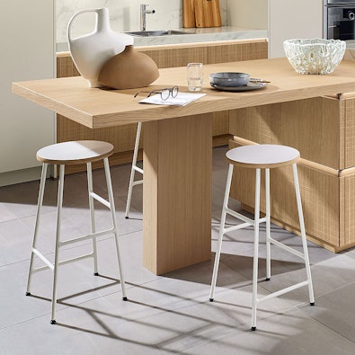 Houten eettafel met moderne barkrukken.