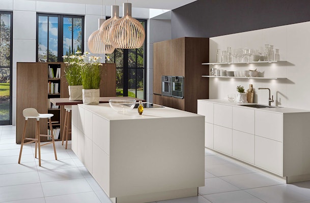 Eilandkeuken in een wit tint gecombineerd met notenhout.