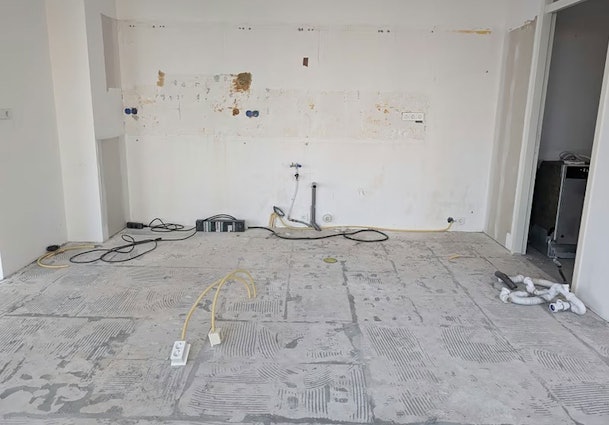 Elektra-aanleg in vloer voor kookeiland met zichtbare leidingen en stopcontactpunten in renovatiekeuken
