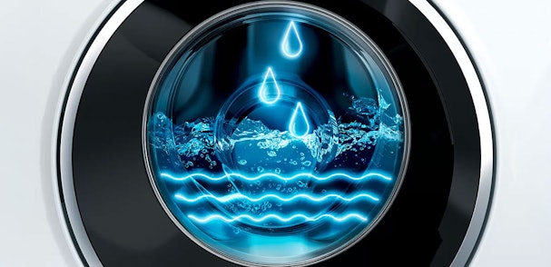 Alternatieve tekst: Wasmachine trommel met water en blauwe waterdruppel-iconen die waterbesparing symboliseren