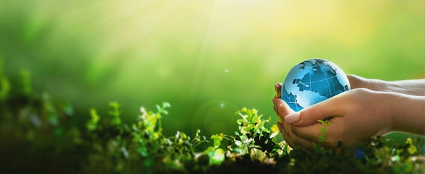 Handen die een wereldbol vasthouden als symbool voor energiezuinige en stille koelkasten