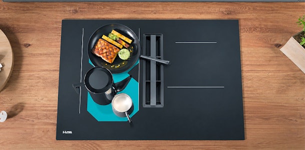 Grillplaat en pannen op de octa zones van een ETNA kookplaat met afzuiging