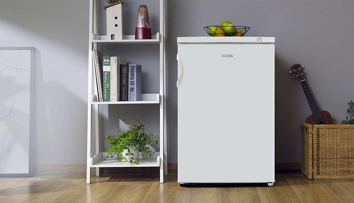 Vrijstaande Etna vriezer in een moderne woonkamer met open wandrek en houten vloer