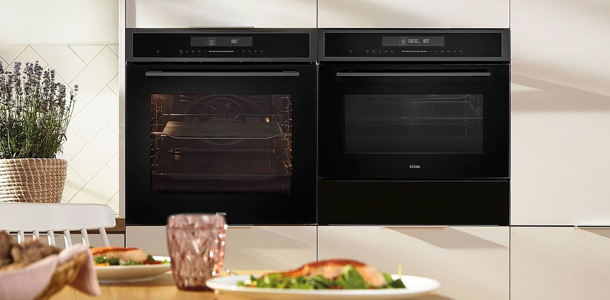 Twee ETNA zwarte inbouw magnetrons naast elkaar in lichte keuken met eettafel en verse maaltijd