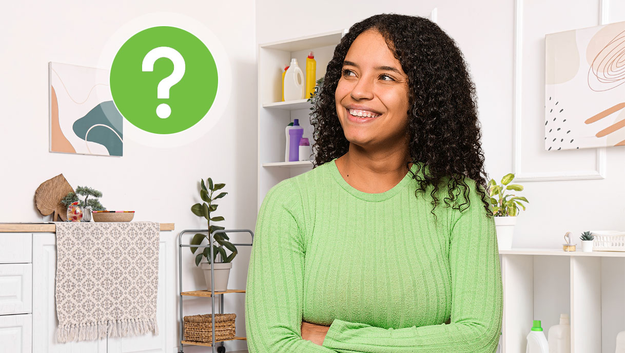 Tevreden vrouw in wasruimte met wasmiddelen op de achtergrond