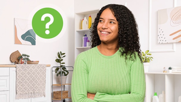 Tevreden vrouw in wasruimte met wasmiddelen op de achtergrond