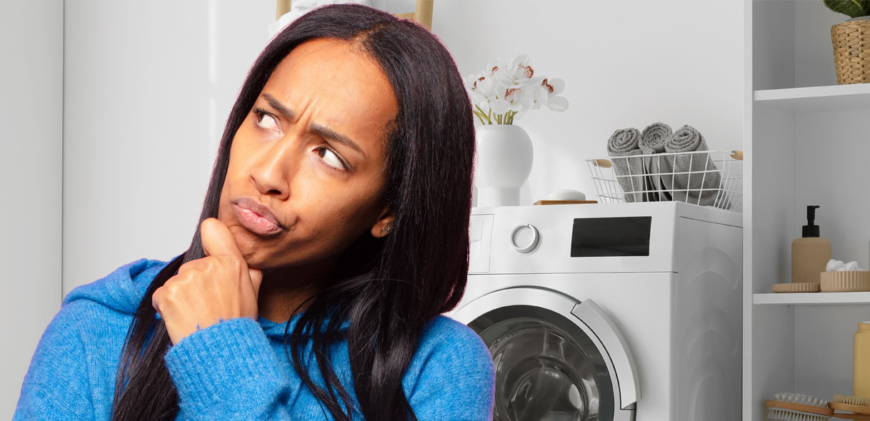 Vrouw denkt na bij haar wasmachine