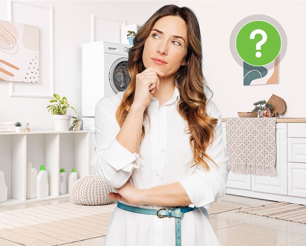 Vrouw met vragende blik in wasruimte met wasmachine – veelgestelde vragen over witte was
