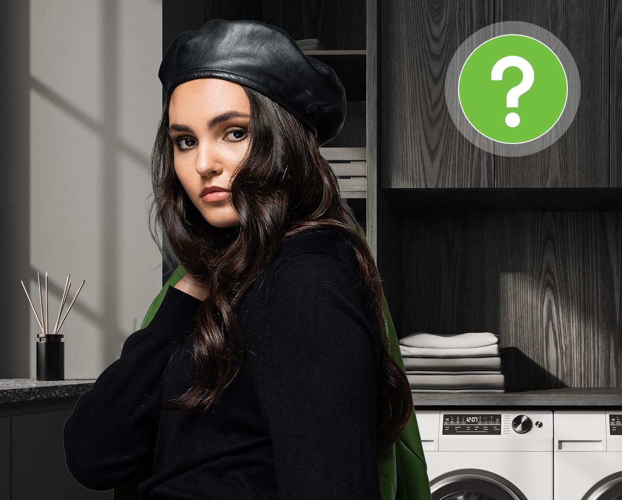 Vrouw in zwarte kleding bij wasmachine met vraagteken over veelgestelde vragen over zwarte was