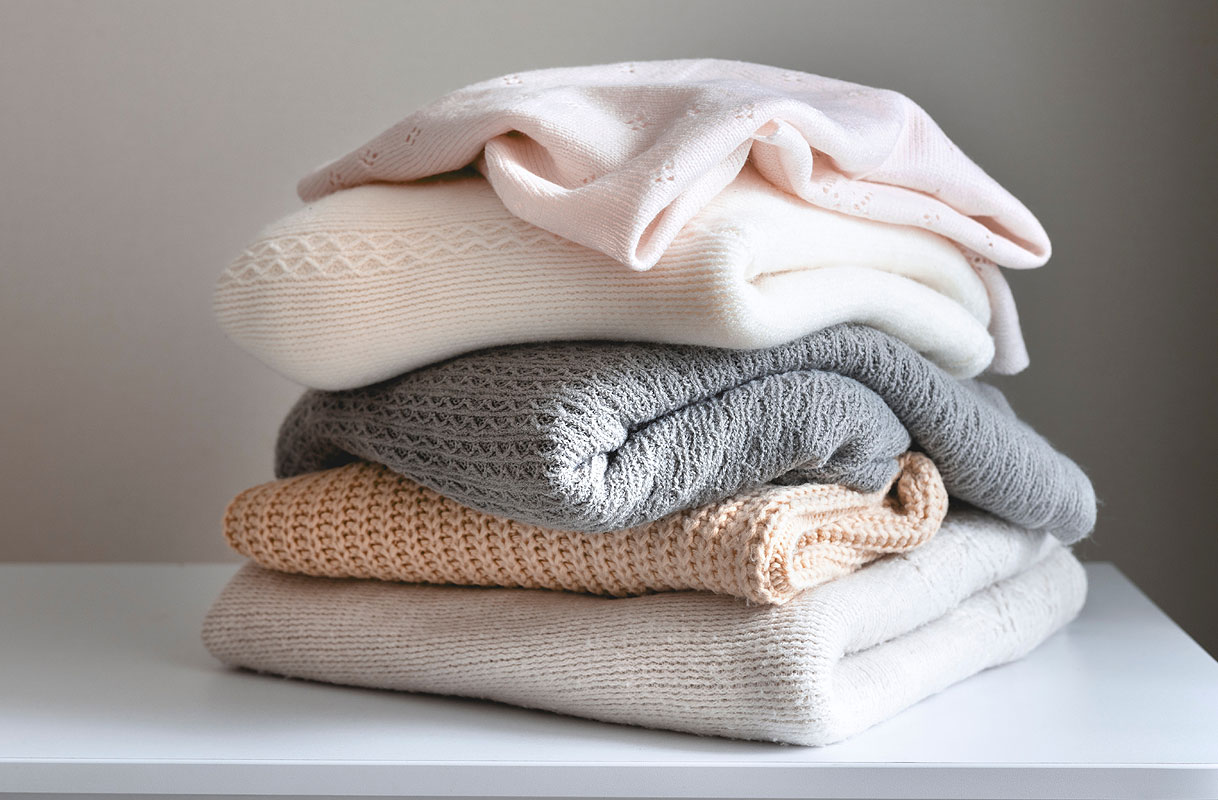 Stapel fijne was: wollen en kasjmier truien in zachte kleuren