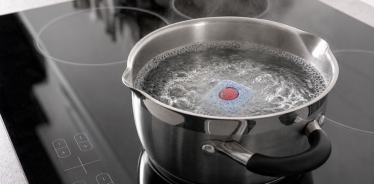 Vaatwastablet lost op in een pan kokend water om het vetfilter uit te koken