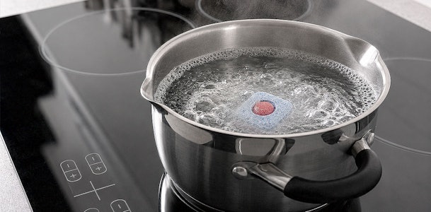 Vaatwastablet lost op in een pan kokend water om het vetfilter uit te koken