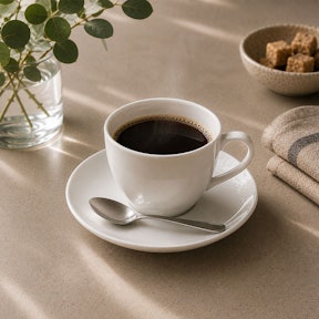 Filterkoffie in een wit porseleinen kopje met schotel