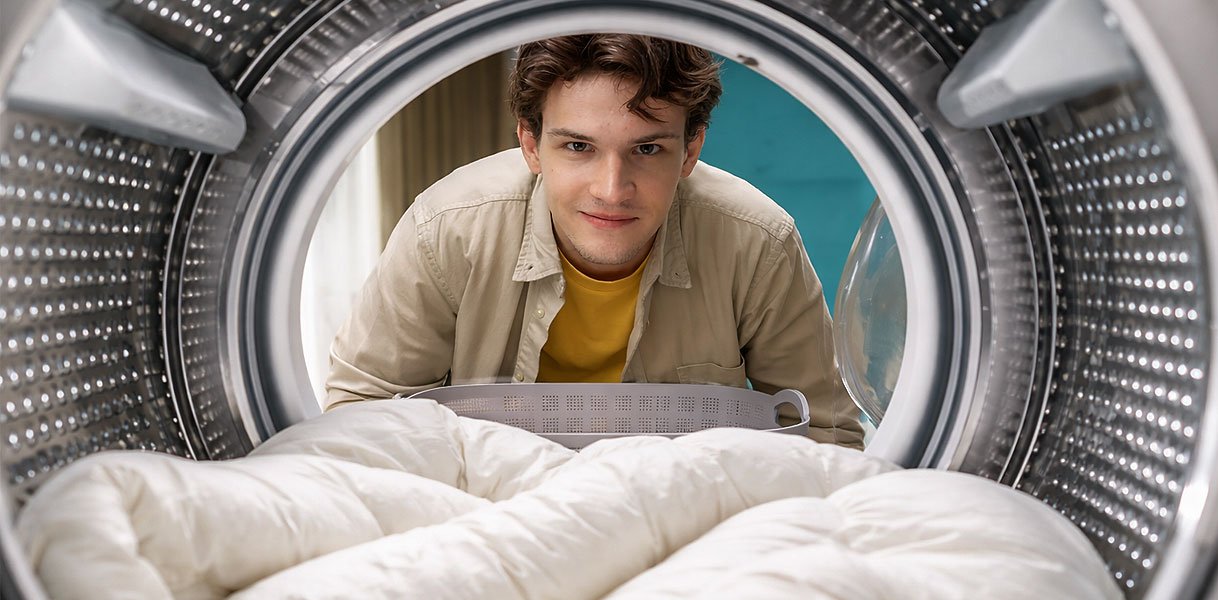 Man kijkt in wasmachine met dekbed in de trommel