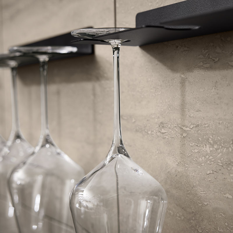 Wijnglashouders tegen travertinwand met glazen bekers