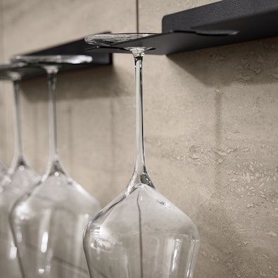 Wijnglashouders tegen travertinwand met glazen bekers