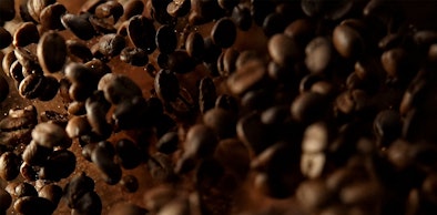 Vallende koffiebonen voor het bonenreservoir met keramisch maalwerk van een Gaggenau koffiemachine