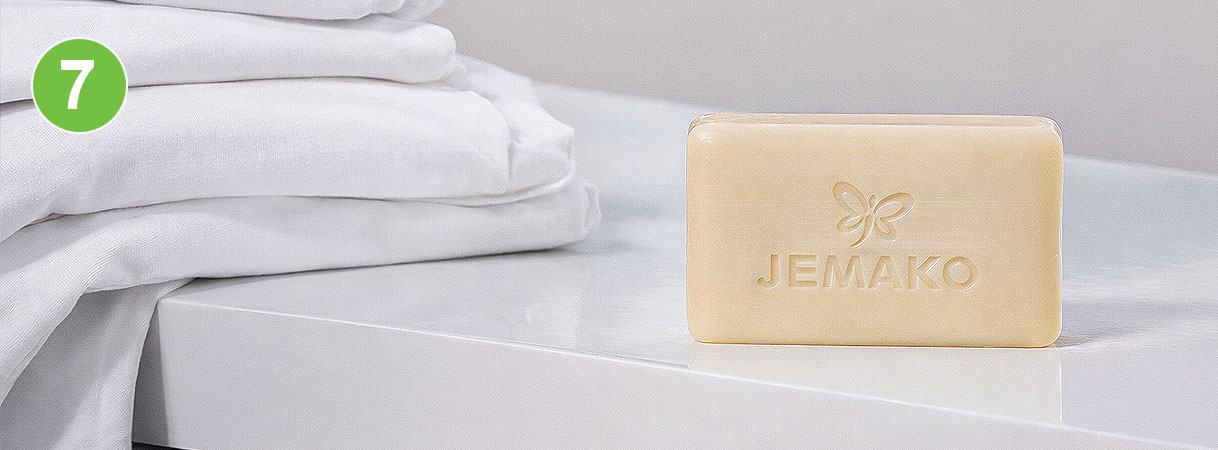 Ossengalzeep voor vlekken: blok Jemako galzeep naast stapel schone witte was