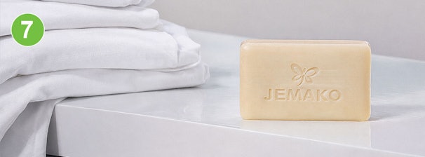 Ossengalzeep voor vlekken: blok Jemako galzeep naast stapel schone witte was