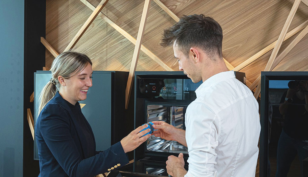 Adviseur legt de bediening van een BORA stoomoven uit aan een klant, met de ovendeur open en het touchscreen aan