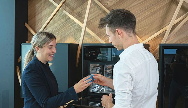 Adviseur legt de bediening van een BORA stoomoven uit aan een klant, met de ovendeur open en het touchscreen aan