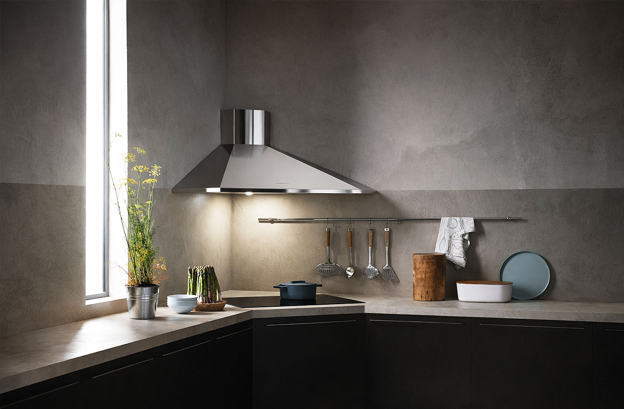 Keuken met traditionele afzuigkap met ingebouwde verlichting boven de kookplaat als contrast met een kookplaat met geïntegreerde afzuiging zonder werklicht