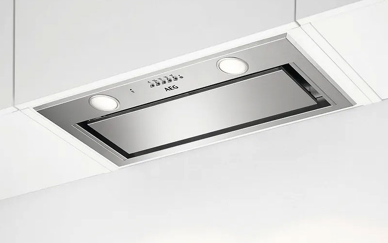 Geïntegreerde afzuigkap volledig weggewerkt in een bovenkast boven de kookplaat voor een strakke en minimalistische keuken.