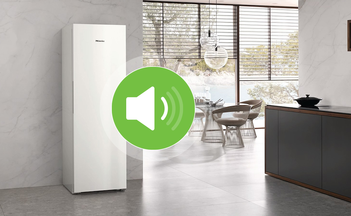 Staande vriezer in een open keuken met een geluidsniveau-icoon op de voorgrond.