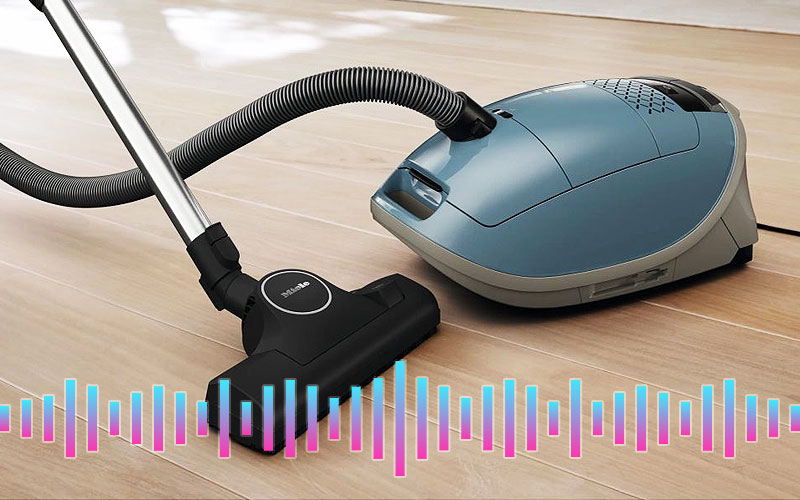 Stofzuiger met zak op houten vloer met geluidsfrequentie – uitleg over geluidsniveau en demping door de stofzak