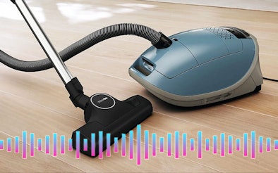 Stofzuiger met zak op houten vloer met geluidsfrequentie – uitleg over geluidsniveau en demping door de stofzak