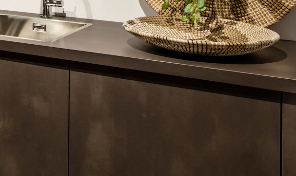 Geoxideerde metaal-look fronten in een industriële keuken.