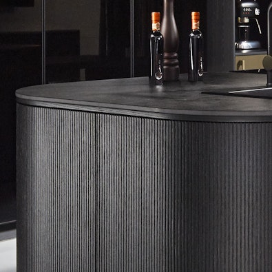 Afgeronde eilandhoek met fijn geribbeld front in zwart.