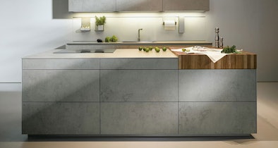 Grijs kookeiland met betonlook fronten en houten werkblad in moderne keuken