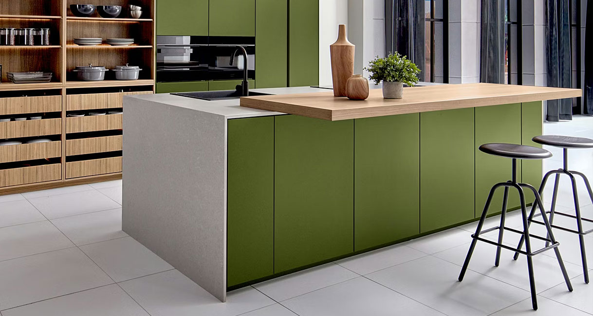 Groen kookeiland met greeploze fronten en houten barblad in moderne keuken