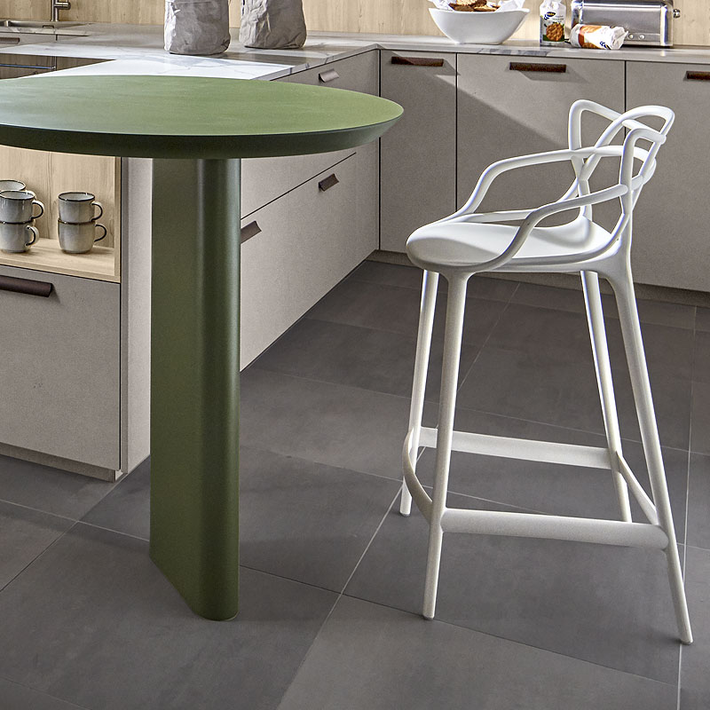 Groen tafeleiland met witte barkruk in lariks-beton keuken.