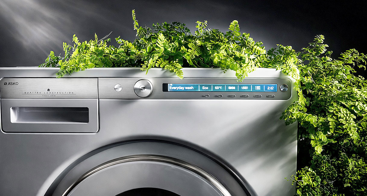 Asko wasmachine in groene modus met planten bovenop en eco programma actief