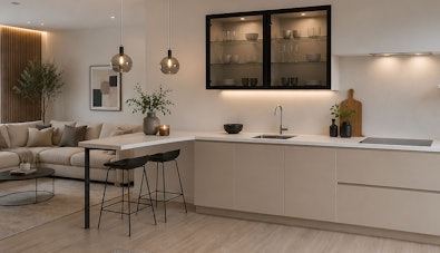 Moderne rechte keuken met haaks barblad, lichte greeploze fronten, zwarte vitrinekasten en twee barkrukken als natuurlijke scheiding tussen keuken en woonkamer.