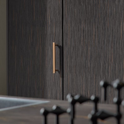 Bronzen handgreep op donker houtdecor.