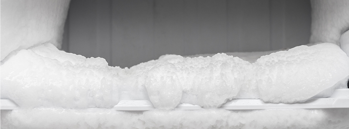 Dikke ijslaag in een handmatig te ontdooien vriezer met beperkte luchtcirculatie.