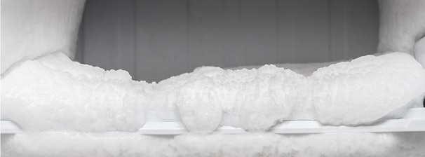 Dikke ijslaag in een handmatig te ontdooien vriezer met beperkte luchtcirculatie.