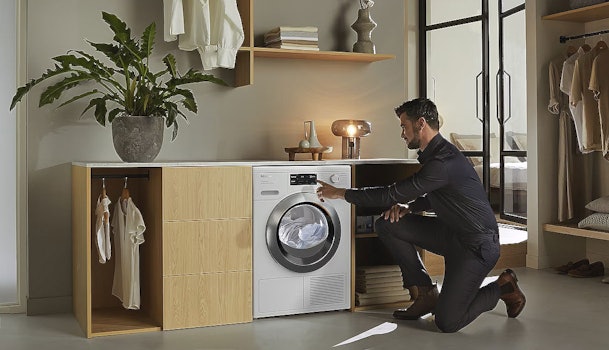 Miele wasdroger DryCare 40 functie - man gebruikt droger in wasruimte