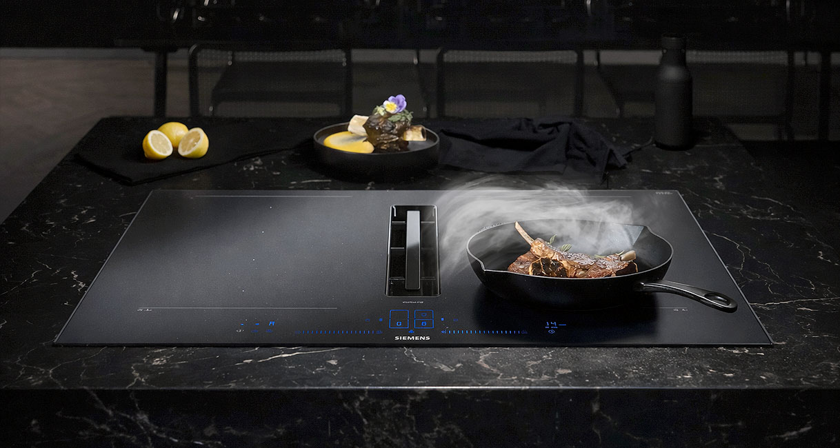 Siemens inductiekookplaat met geïntegreerde afzuiging en InductionAir technologie tijdens het koken met een pan