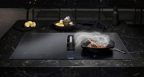 Siemens inductiekookplaat met geïntegreerde afzuiging en InductionAir technologie tijdens het koken met een pan