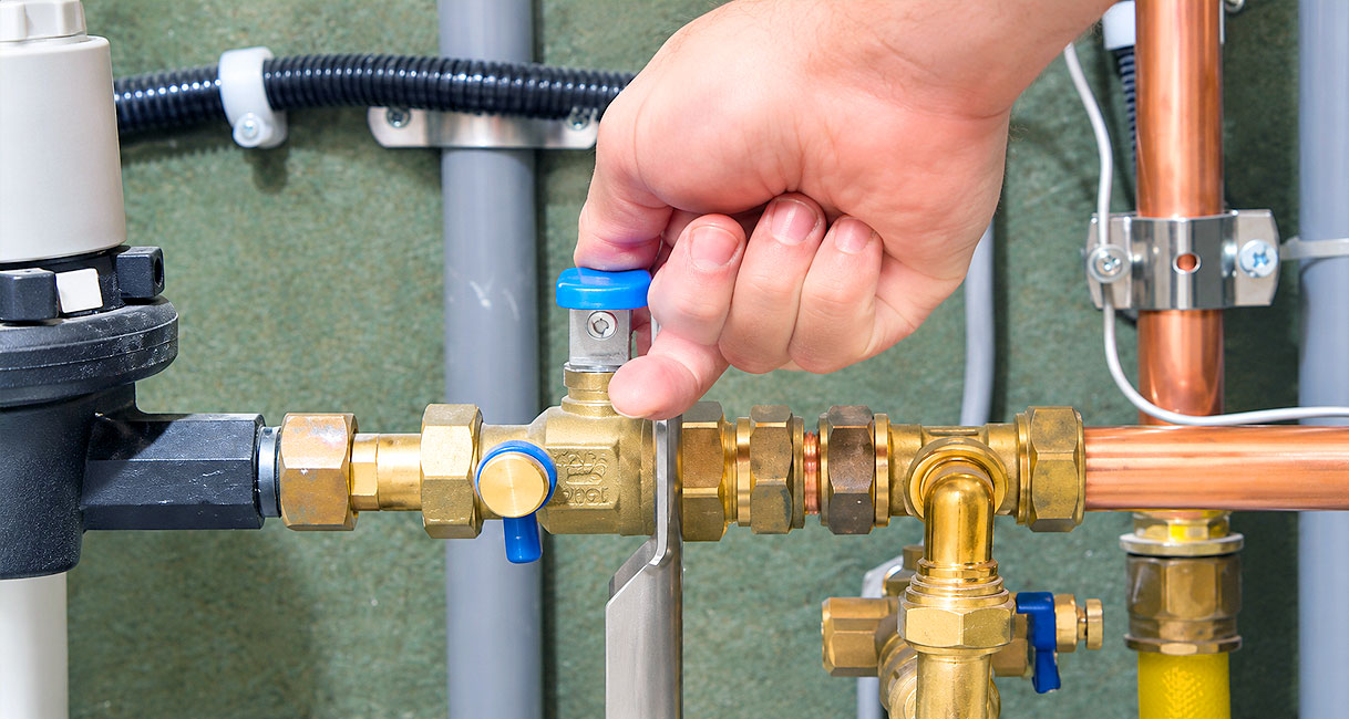 Hand draait stopkraan dicht om de watertoevoer af te sluiten voor reparatie van keukenkraan