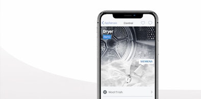 Smartphone met Siemens Home Connect app voor bediening droger op afstand met Wool finish programma