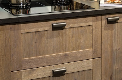 Houten keukenkasten met paneel deurtjes.