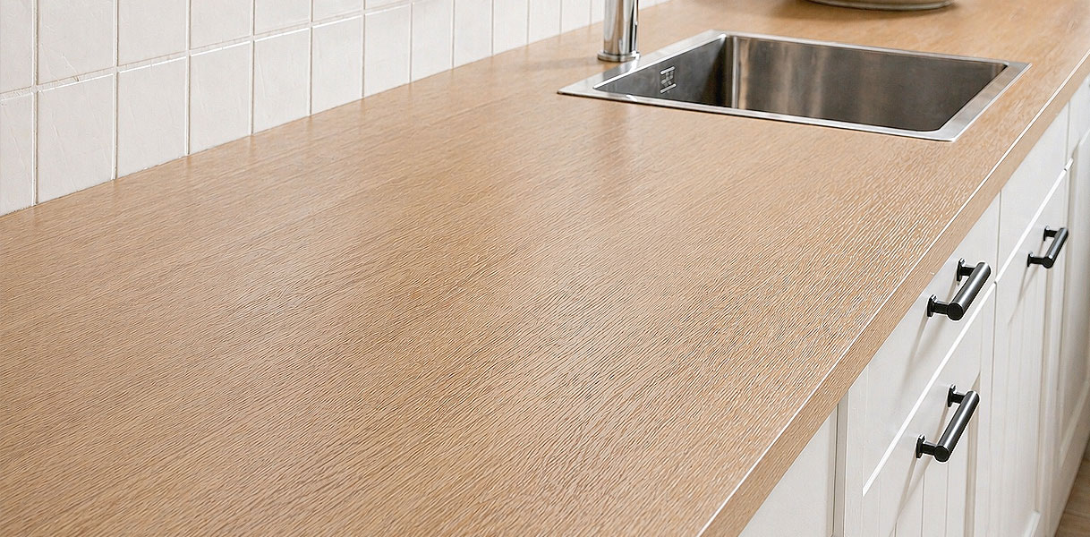 Houten werkblad in landelijke keuken met inbouwspoelbak, kraan en greepjes op fronten