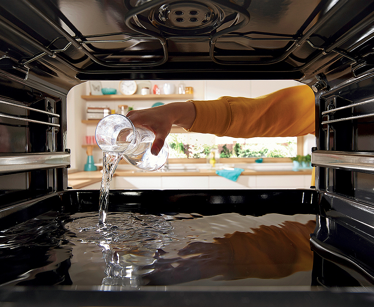 Water wordt in oven gegoten voor stoomreiniging